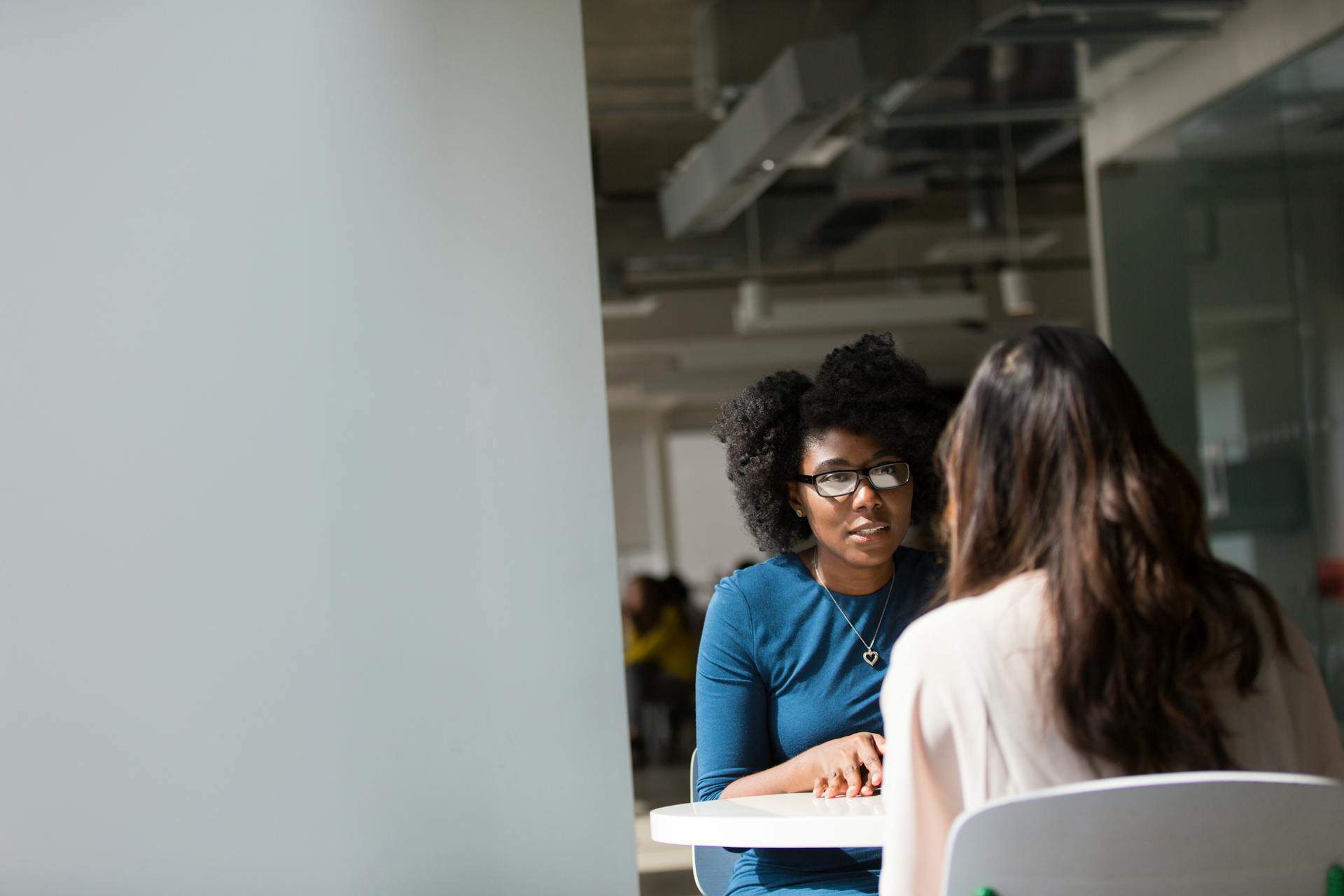 Two women are sat across the table from each other